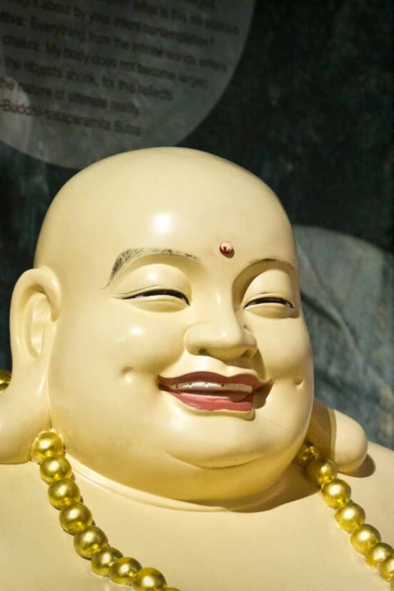 A statue of a fat smiling Buddha