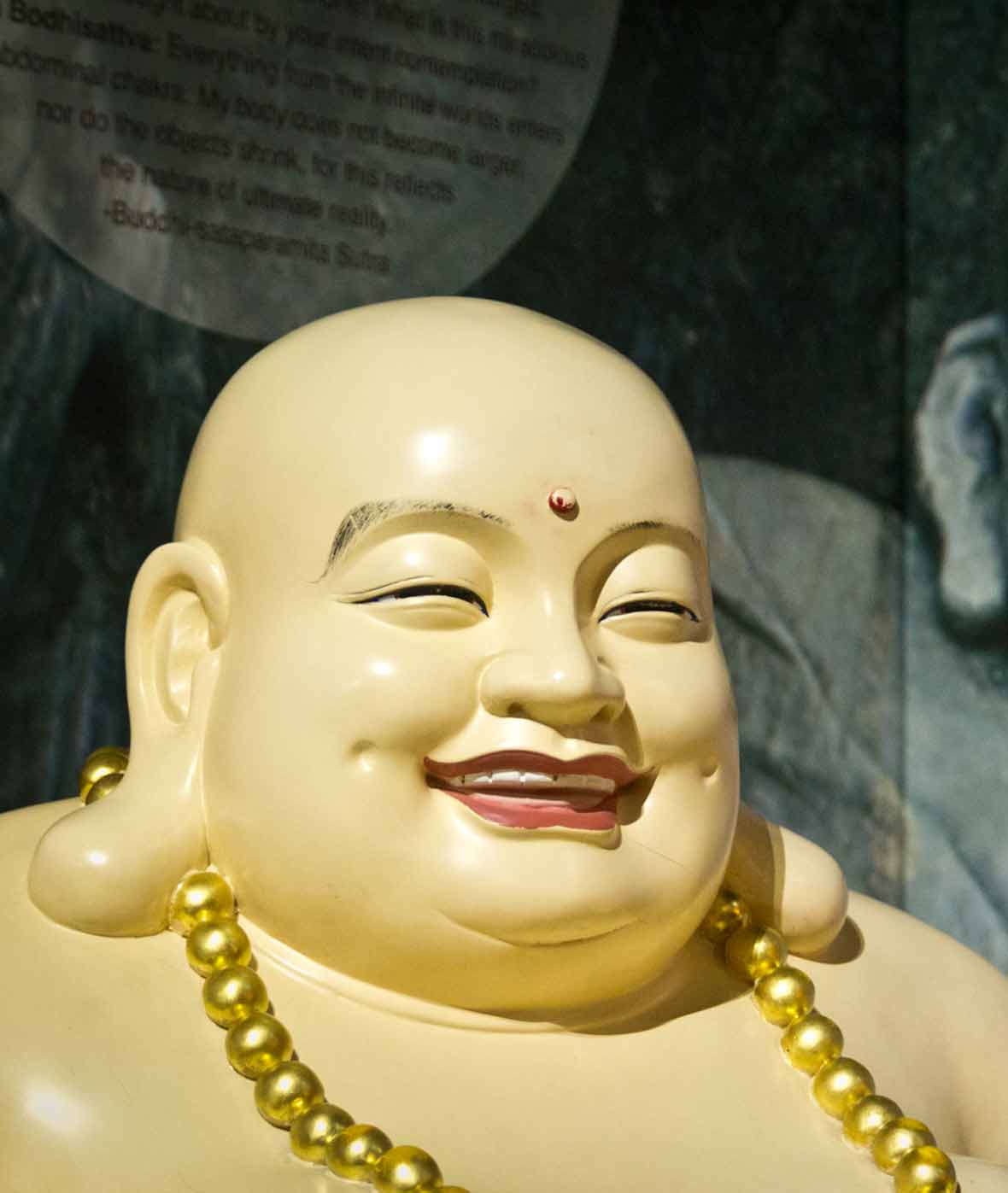 A statue of a fat smiling Buddha