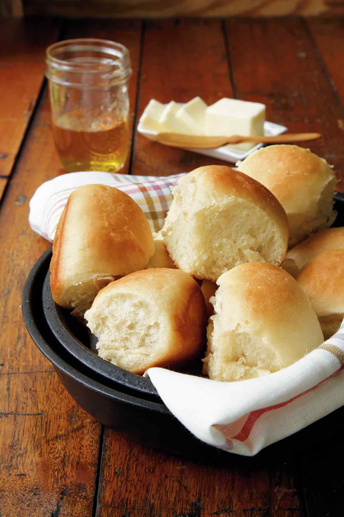A bowl lined with a napkin and filled with pull-apart rolls
