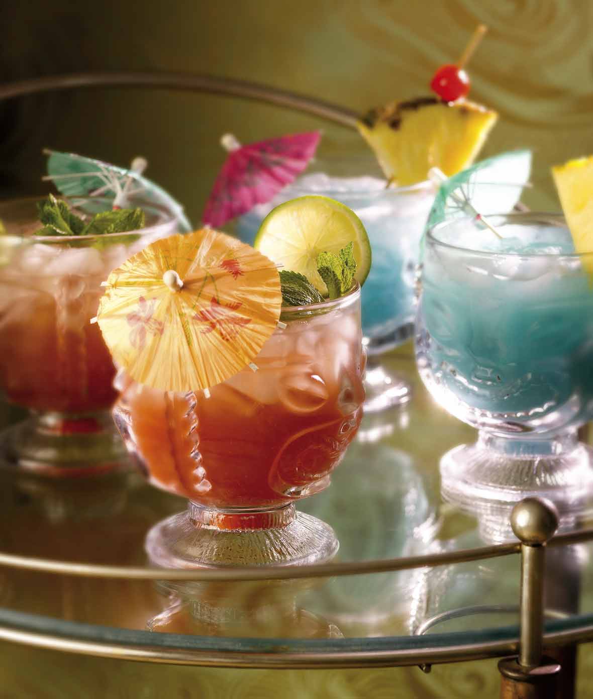 Two of each mai tai and blue Hawaiian cocktails, in glass tiki glasses and garnished with paper umbrellas on a tray.