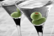 Two classic martinis, each garnished with two green olives.