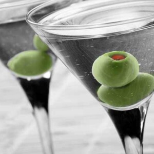 Two classic martinis, each garnished with two green olives.
