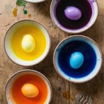 Four bowl filled with Easter egg dye and white eggs.