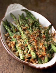Oval casserole dish with spring asparagus and Asiago gratin, topped with coarse bread crumbs