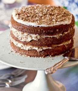 A three-layer hummingbird cake with a cake server beside it.