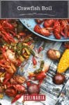 A newspaper-topped table strewn with crawfish, corn, peppers, and potatoes - a classic crawfish boil.