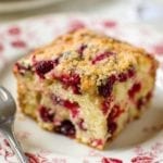 A square of cranberry buckle with a streusel top and studded with cranberries.