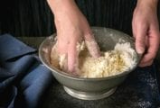 Shortcut pie crust being mixed together by hand in a bowl.