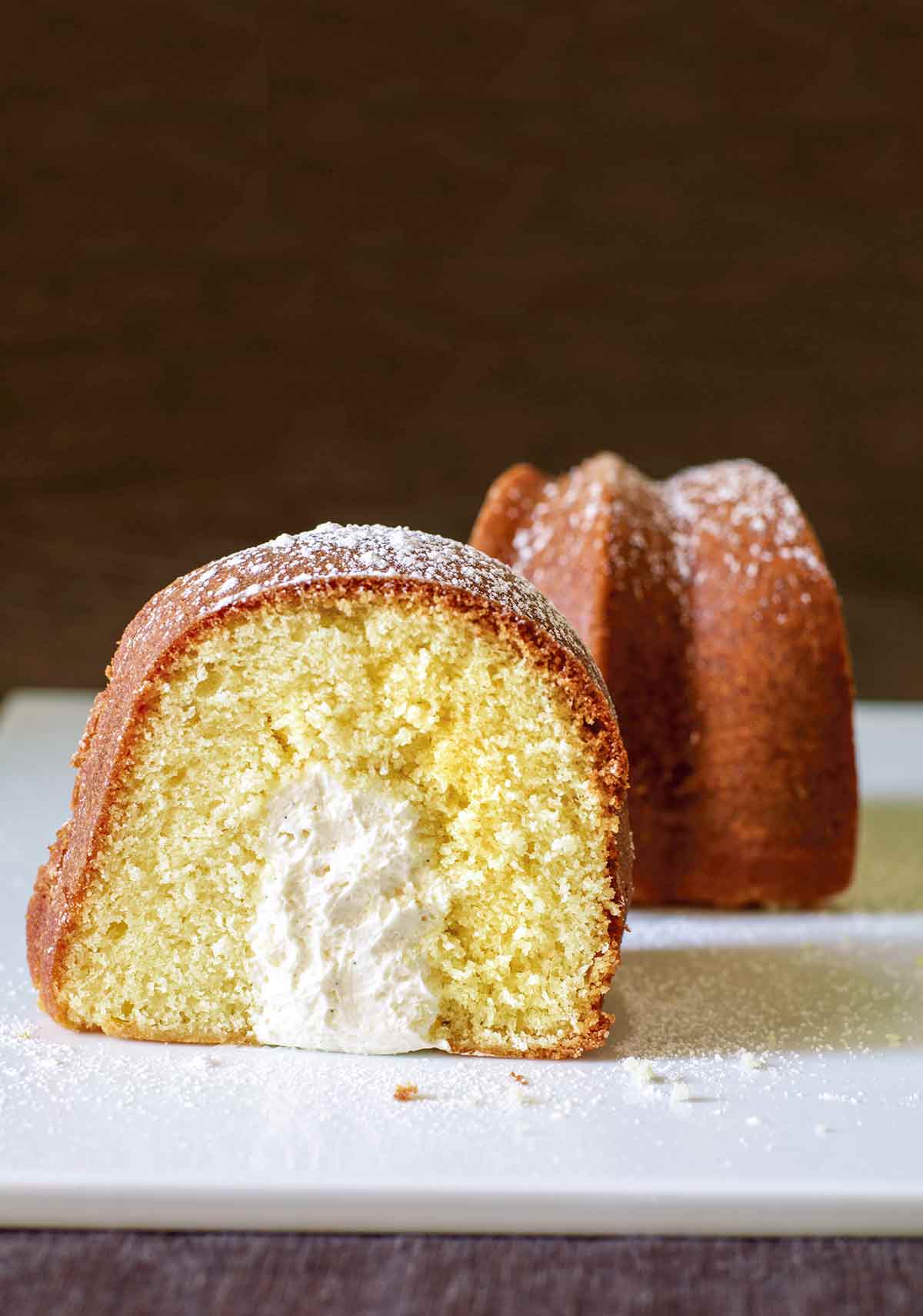 A slice of twinkie bundt cake dusted with confectioners' sugar and turned to show the cross section.