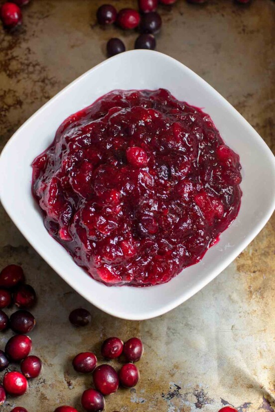 Cranberry and orange relish in a white bowl on a baking sheet