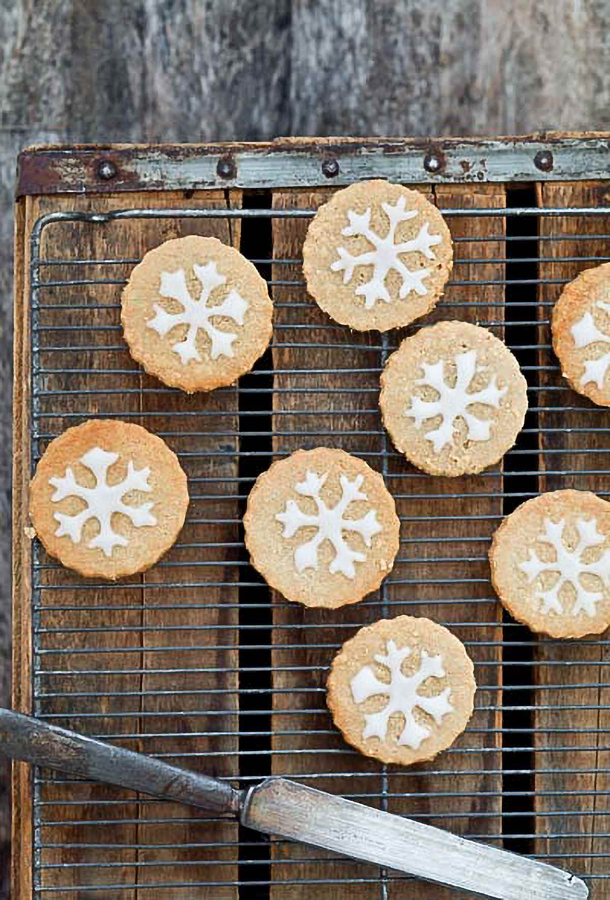 Round wheat-free butter cookies on a cooling rack set over a wooden board.