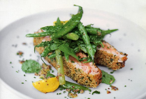 A white plate topped with salmon fish fingers, asparagus, spring peas, and a wedge of lemon.
