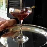 A silver tray with a glass filled with the fatty daddy cocktail – bourbon, bacon infused cherry syrup, cherries.