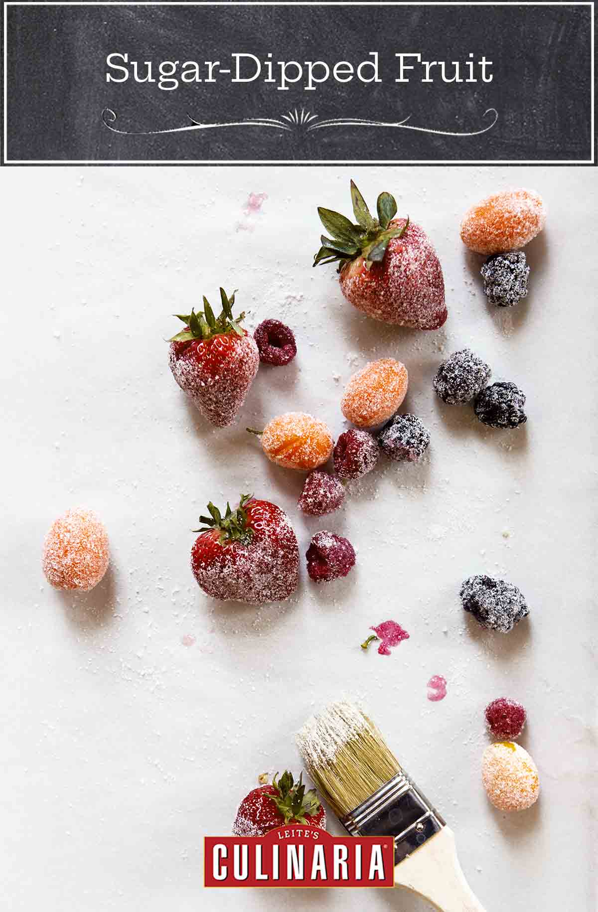Various berries and fruit dipped in sugar on a sheet of parchment.