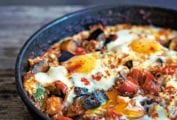 A skillet of eggs with chorizo and eggplant, tomato, zucchini, onion, and peppers.