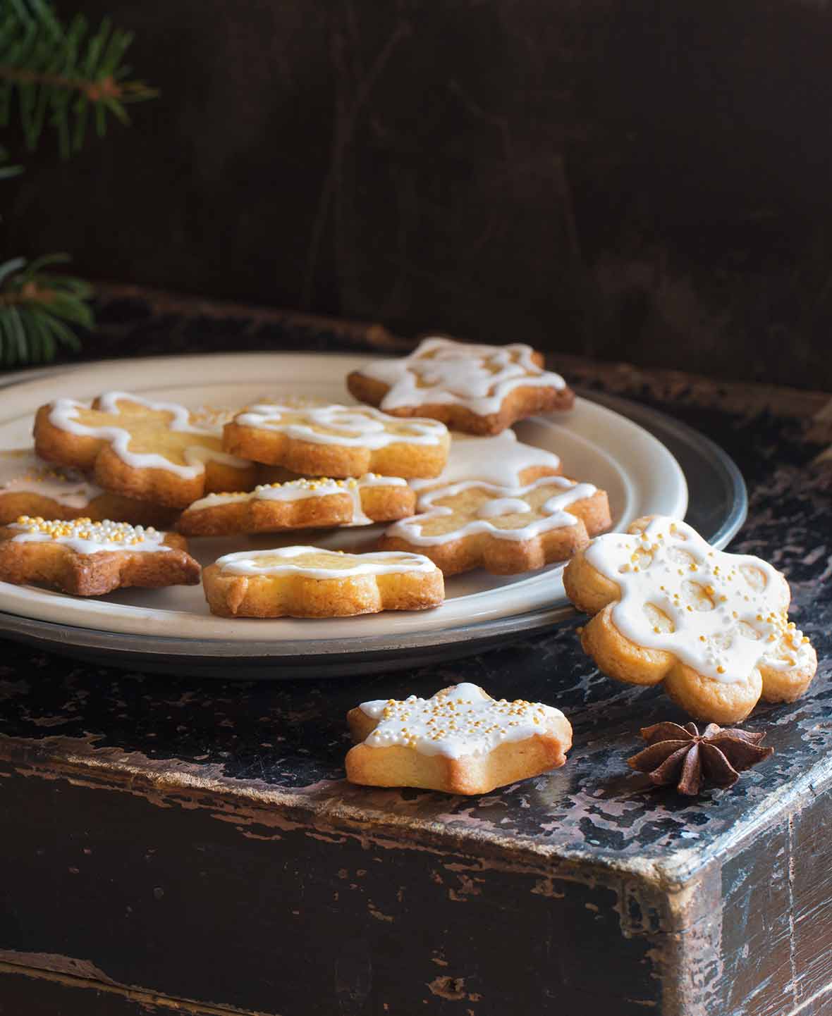 A white plate with a pile of sugar cookies coated in a champagne glaze.