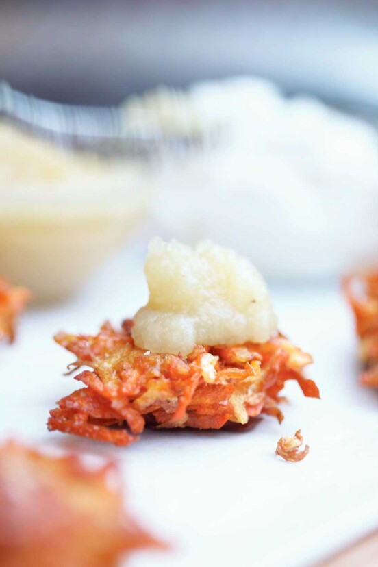 A root vegetable latke topped with a dollop of applesauce.