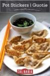 A white oval plate filled with pot stickers, a pair of chopsticks, and dipping sauce.