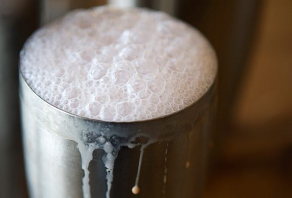 A metal shaker filled with egg cream.