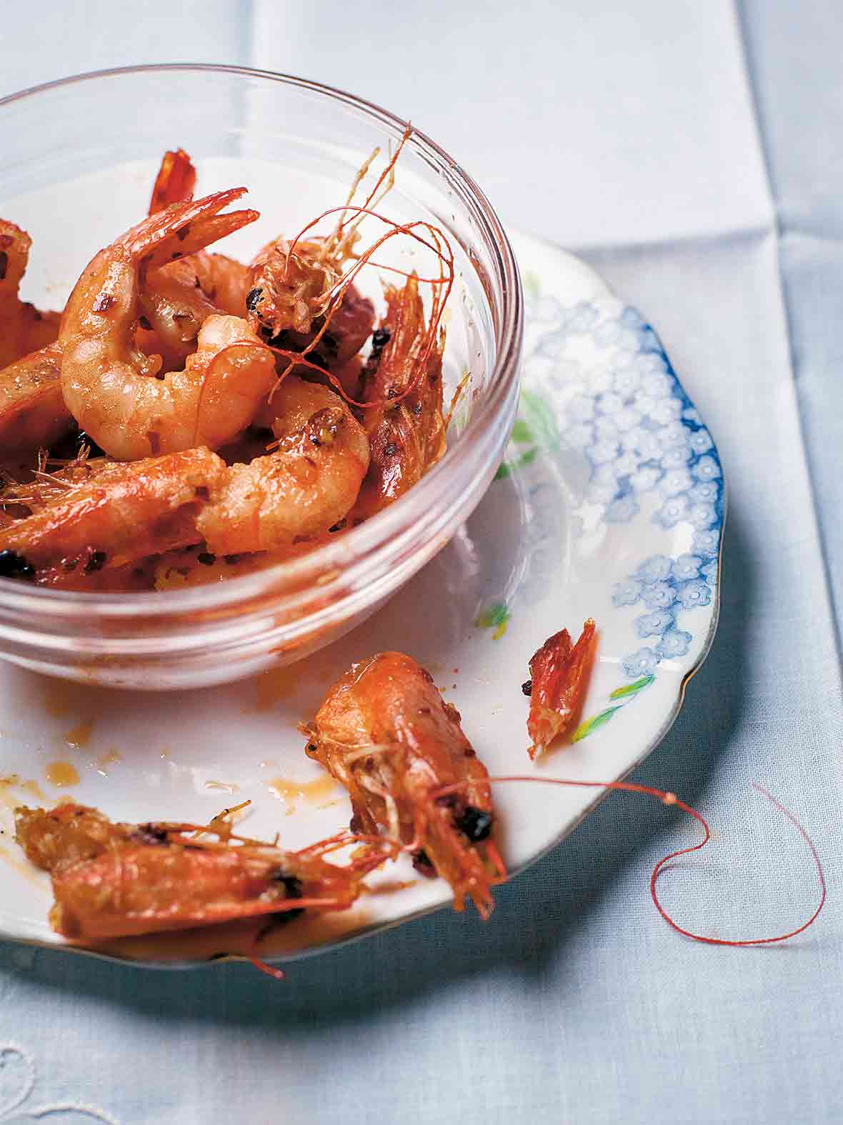 Glass bowl filled with garlic shrimp, sautéed with oil, butter, chiles pepper, and garlic
