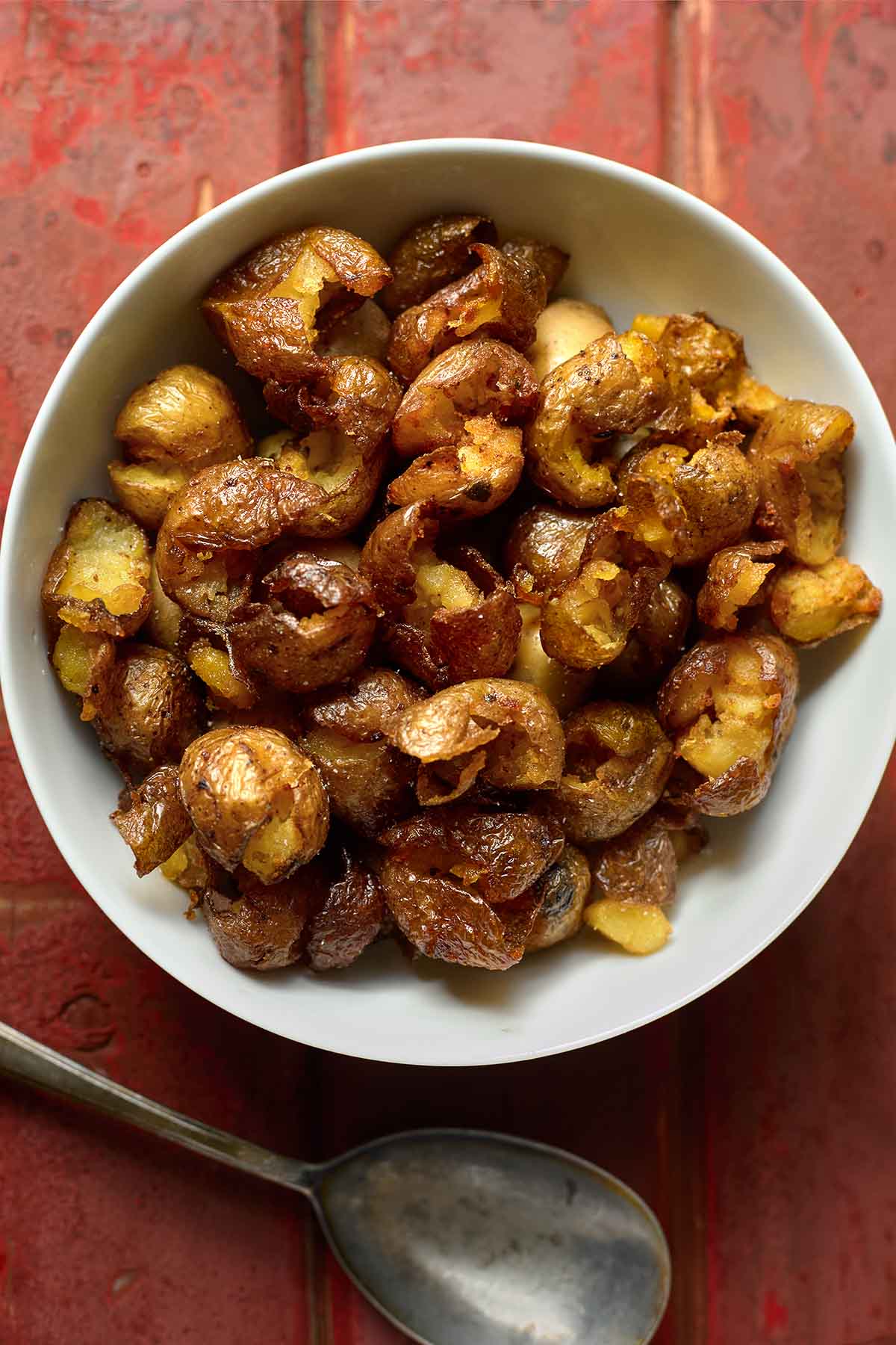 An overhead shot of a bowl of hot deep-fried new potatoes that have been pickled and smoked.