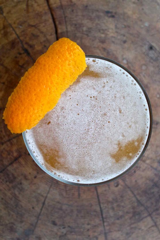 An overhead view of a down Easter cocktail, topped with a strip of orange zest.