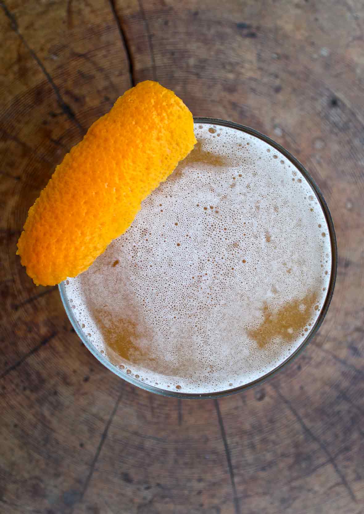 An overhead view of a down Easter cocktail, topped with a strip of orange zest.