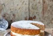 A maple parsnip cake with mascarpone frosting between the layers on a grey plate.
