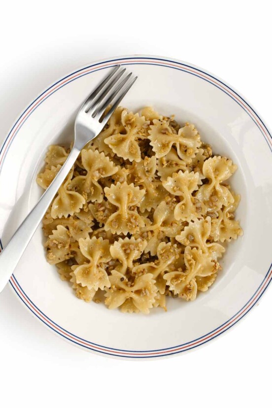 A white bowl filled with bowtie pasta and kasha, called kasha varnishkes.