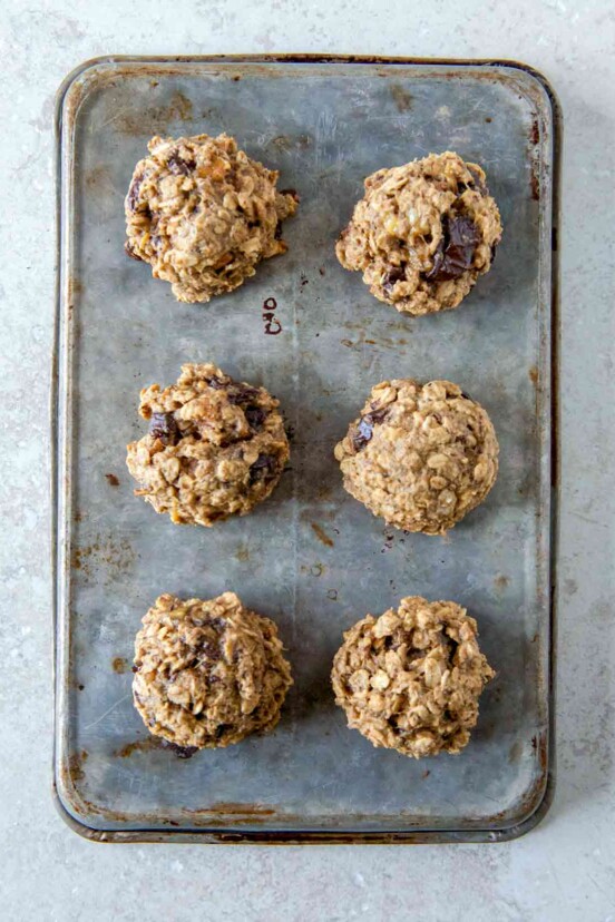 A cookie sheet with six breakfast cookies with oats, banana, figs, and peanut butter.