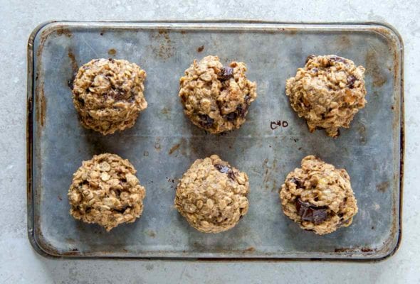 A cookie sheet with six breakfast cookies with oats, banana, figs, and peanut butter