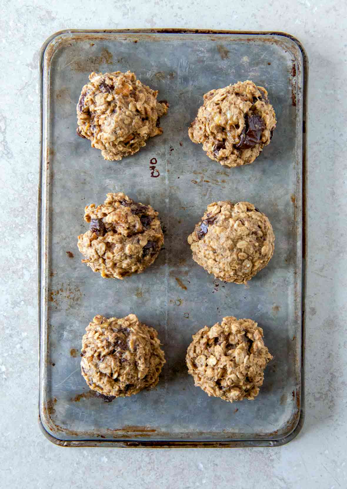 A cookie sheet with six breakfast cookies with oats, banana, figs, and peanut butter.