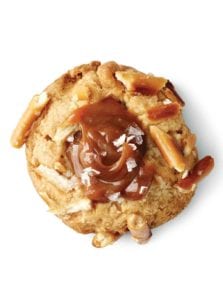 A salted caramel and pretzel cookie topped with flaked sea salt and pieces of pretzel.