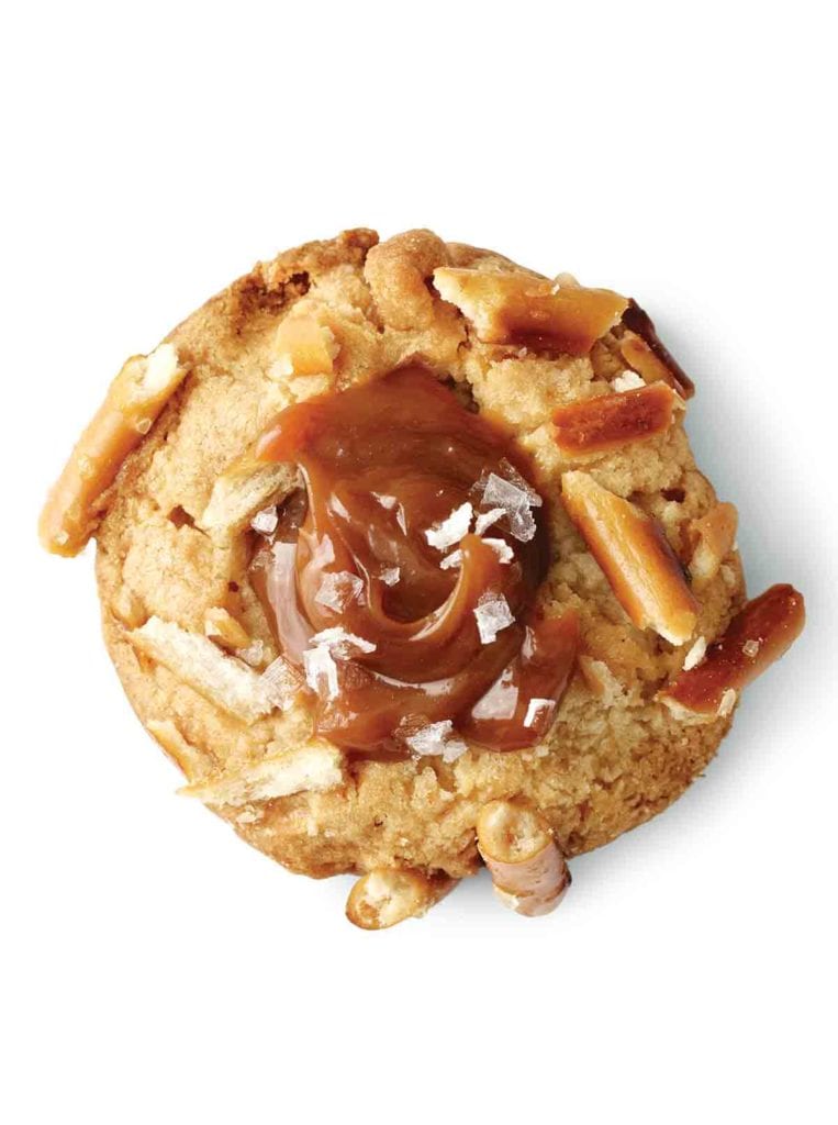 A salted caramel and pretzel cookie topped with flaked sea salt and pieces of pretzel.