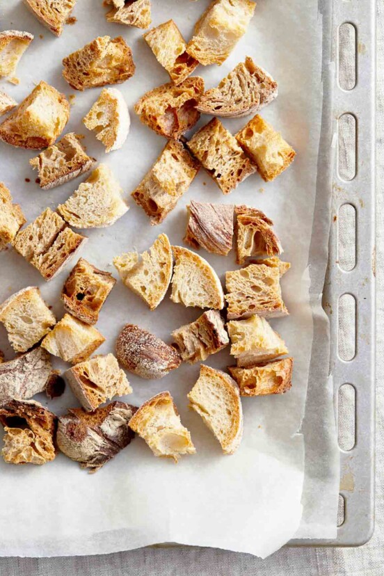 Homemade croutons in a parchment-lined baking sheet