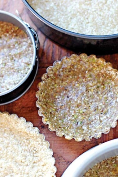 Five Vegan, Gluten-Free, and Paleo Pie Crusts each in their own tart shell or pie pan.