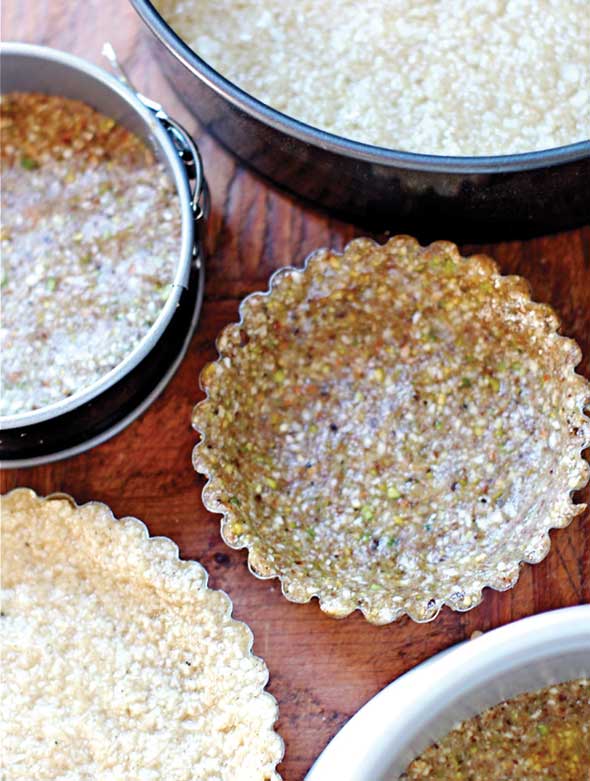 Five Vegan, Gluten-Free, and Paleo Pie Crusts each in their own tart shell or pie pan.