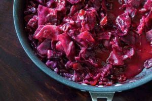 A Calphalon skillet filled with braised red cabbage with cranberries.