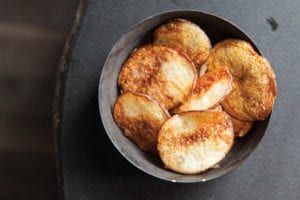 A grey bowl filled with baked potato chips