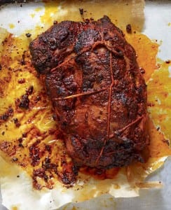 A pork loin roast with paprika on a foil tray
