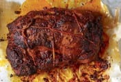 A pork loin roast with paprika on a foil tray
