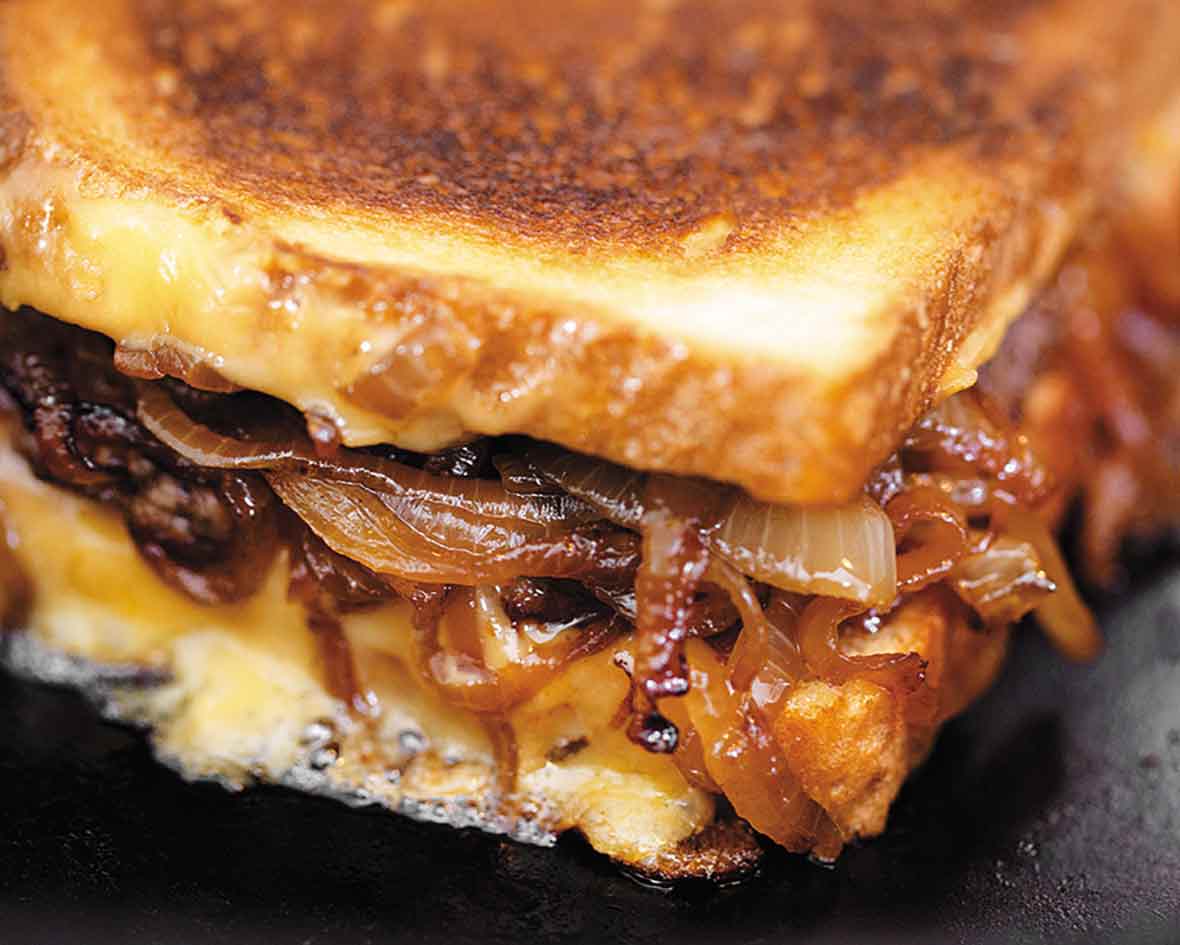 A patty melt sandwich filled with ground beef, caramelized onions and cheese.