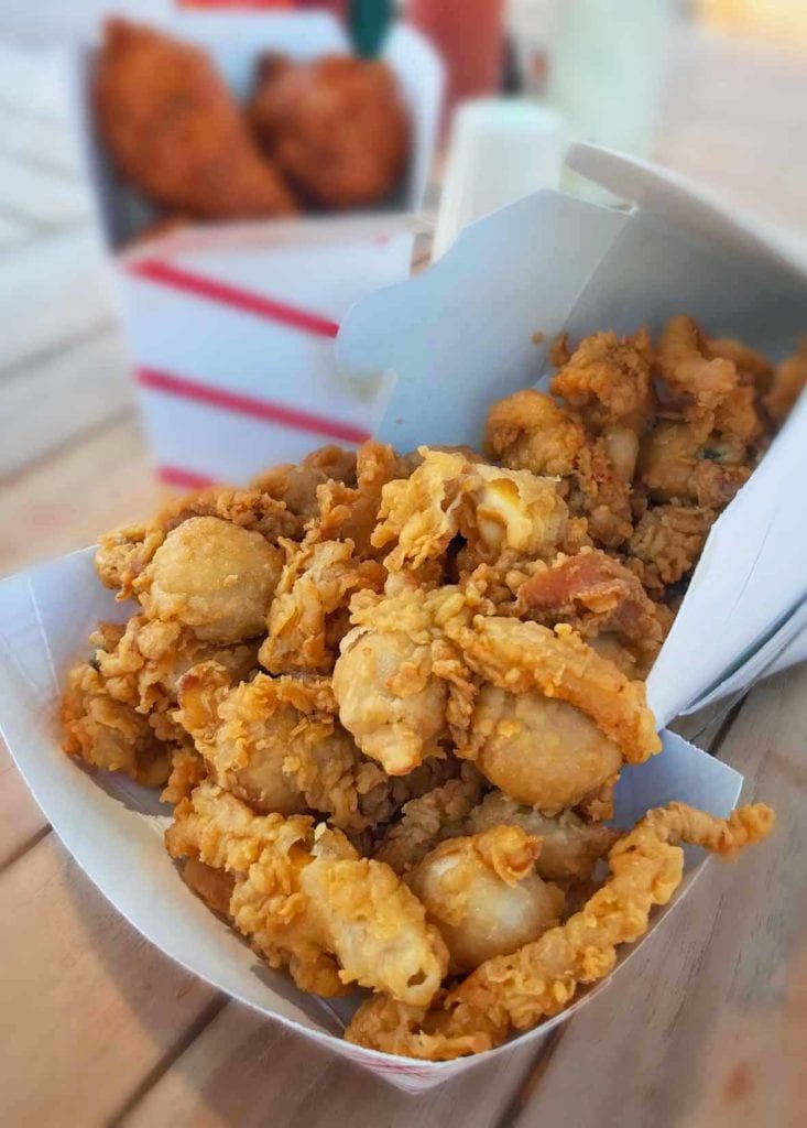 A paper basket filled with golden fried clams