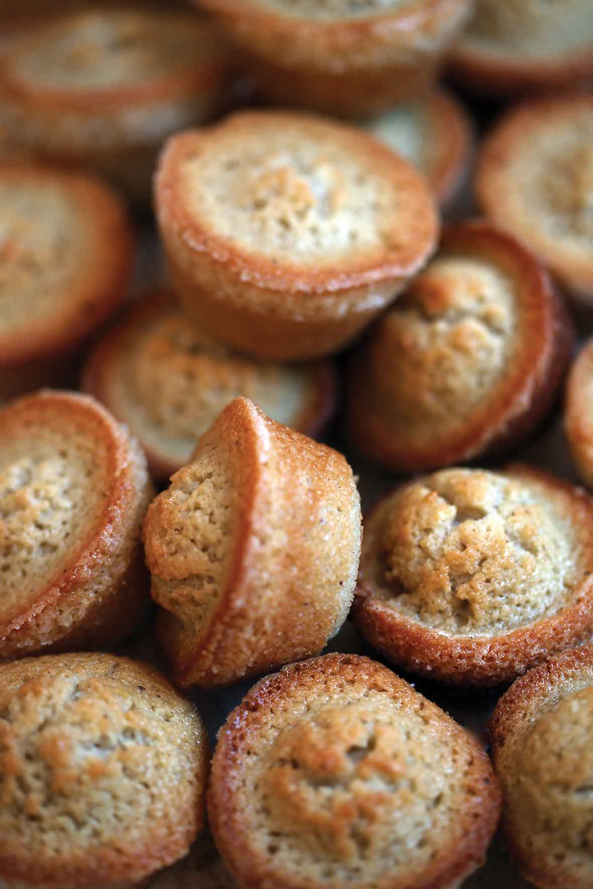 A pile of brown butter financiers baked in mini muffin molds.