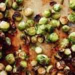 Crispy roasted Brussels sprouts on a rimmed baking sheet.