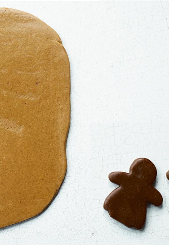 Pieces of light and dark gingerbread, with two people cut out of the dark, and a tree shape cut out of the light gingerbread.