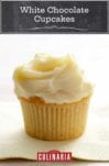 A single white chocolate cupcake, topped with white frosting on a paper napkin.