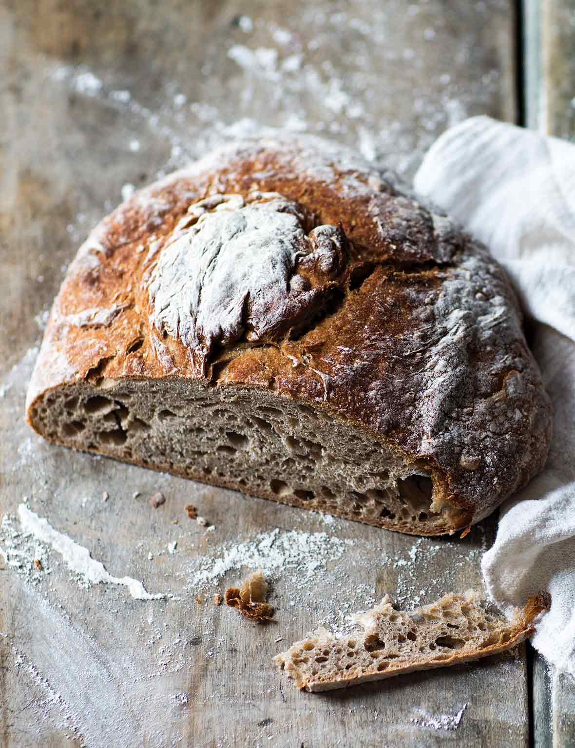 A loaf of Galician rye bread with a slice cut off to show the airy texture.