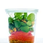 A grapefruit and watercress salad in a glass jar.