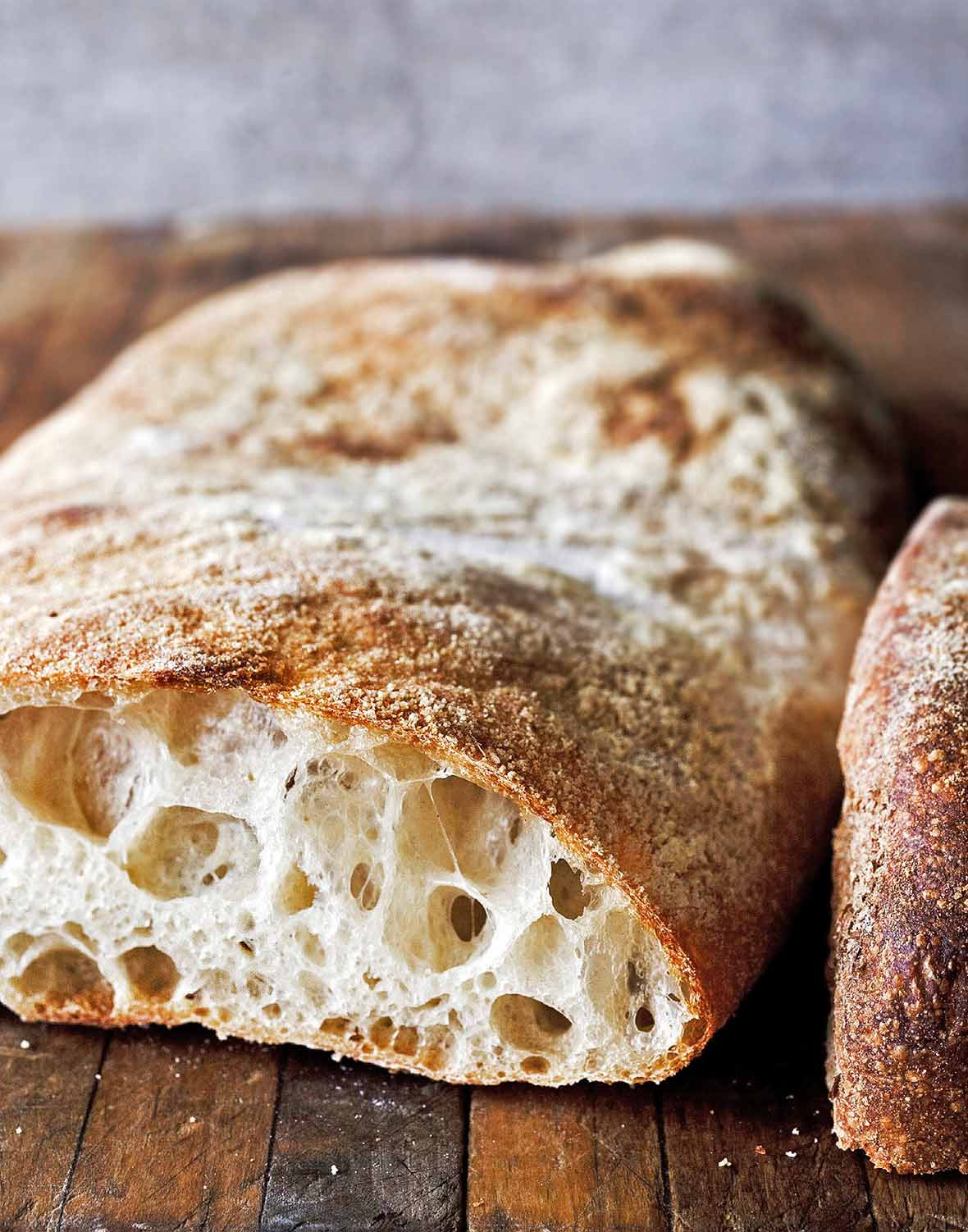 A loaf of ciabatta, sliced, and filled with large air holes.